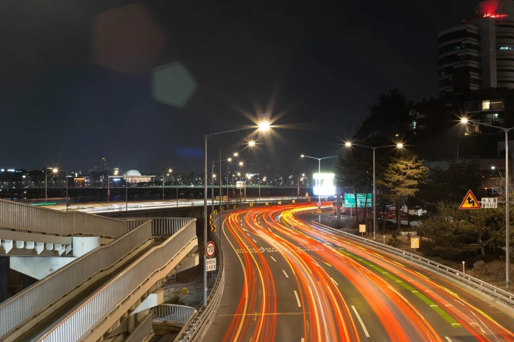 Night view of Olympic-daero in Seoul, with illuminated highways and city lights along the Han River.