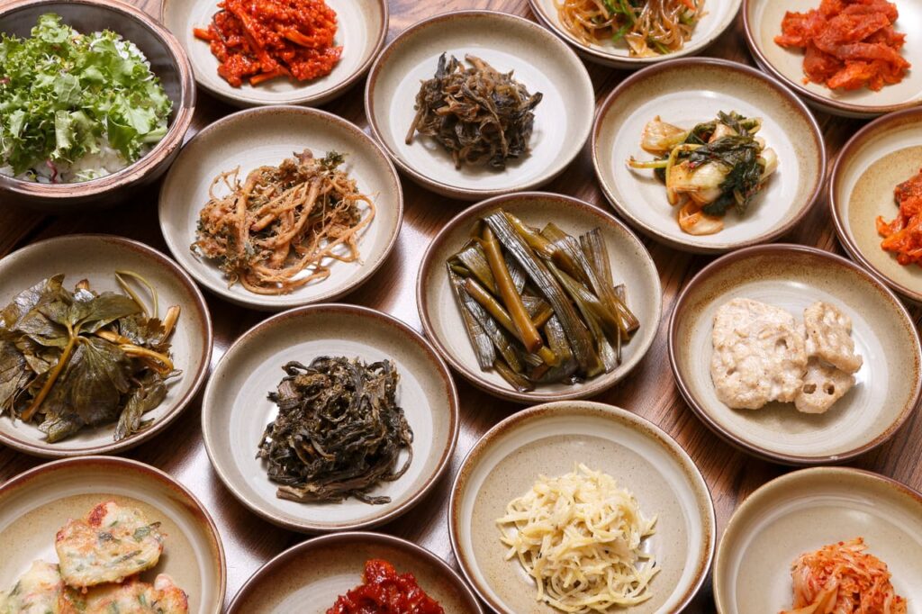 Many plates filled with assorted mountain vegetables and side dishes.